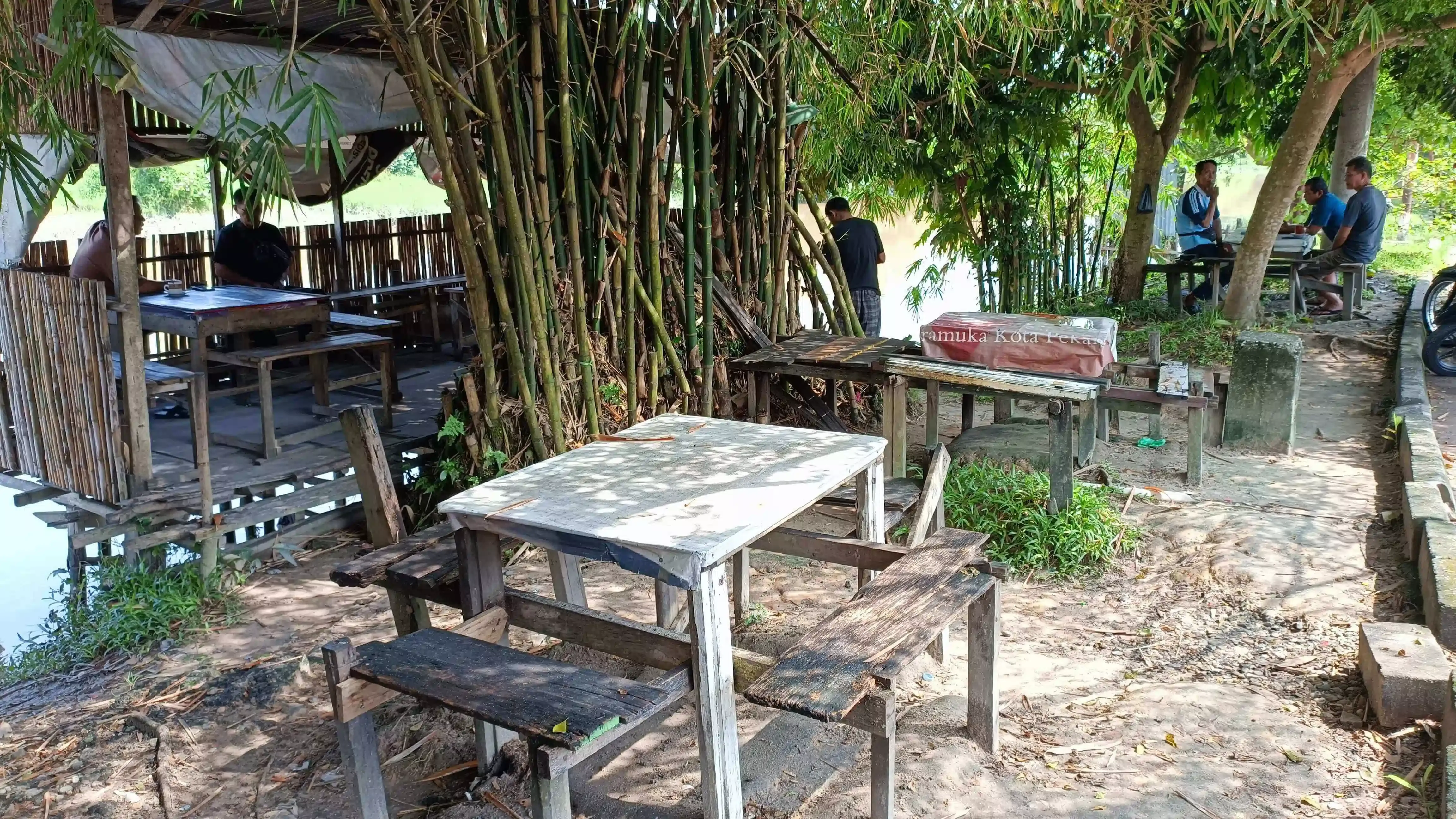 Area outdoor kedai kopi dengan suasana santai, udara terbuka, dan lingkungan yang asri.